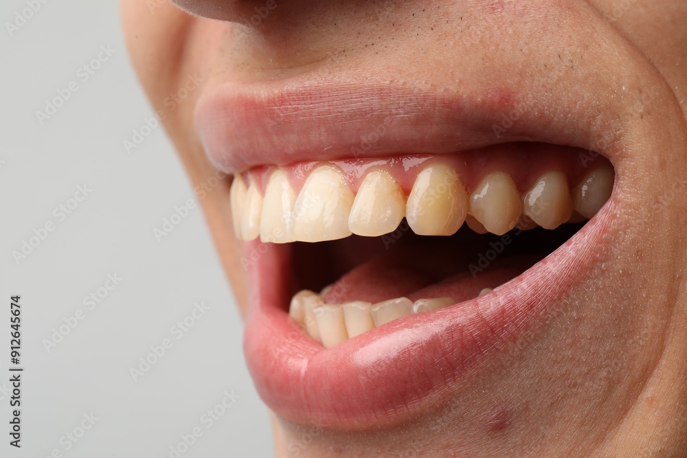 Obraz premium Smiling man with healthy clean teeth on light background, closeup