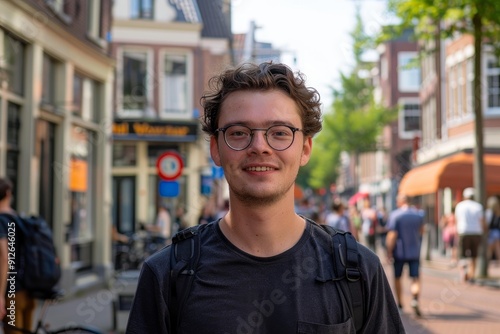 Young man is smiling while walking down a busy city street during the day