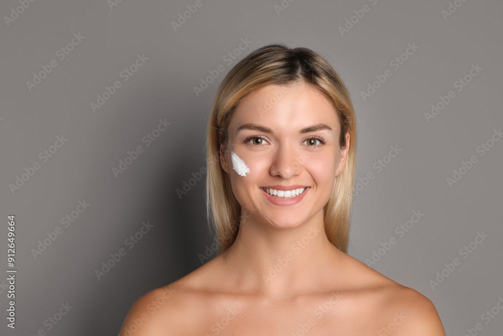 Beautiful woman with cream on her face against grey background Beautiful woman with cream on her face against grey background