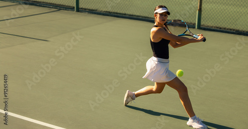 Obraz na plátně Woman playing tennis with racket and ball on the court during holiday
