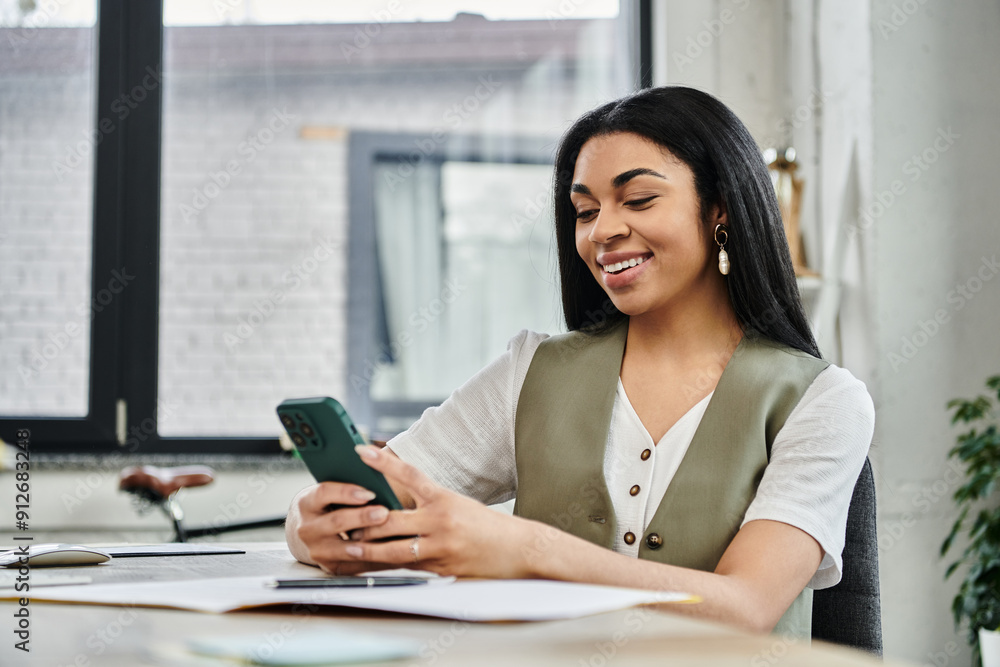 A stylish woman smiles while using her smartphone in a cozy office setting. A stylish woman smiles while using her smartphone in a cozy office setting.