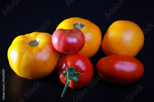 fresh ripe tomatos with water drops in studio on a black background	
