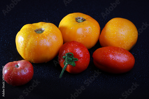 fresh ripe tomatos with water drops in studio on a black background	
