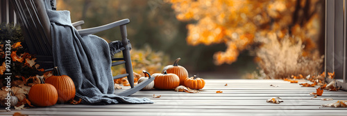 Autumn background with copy space for text, cozy front porch, rocking chair, pumpkins, blanket. Fall season background, card, banner