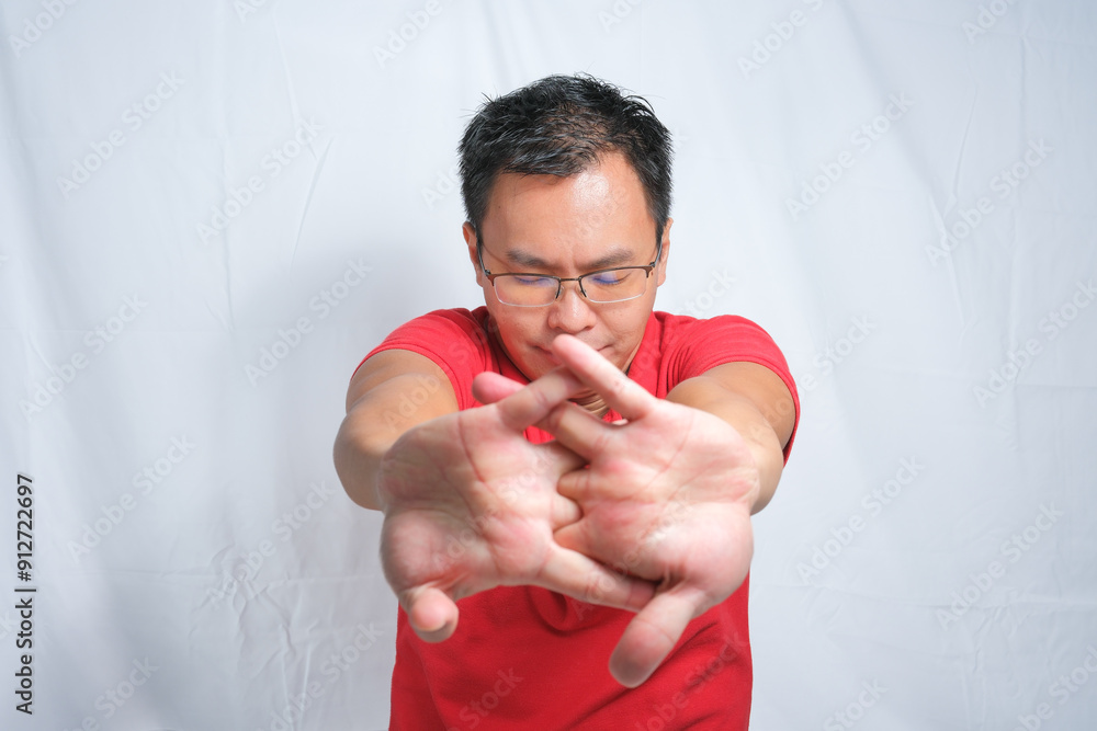Young asian man with glasses doing hand stretching toward the camera on isolated white background. Indonesian Man wearing red shirt and glasses Isolated white background. Young asian man with glasses doing hand stretching toward the camera on isolated white background. Indonesian Man wearing red shirt and glasses Isolated white background.