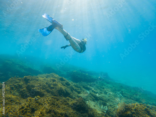 Wallpaper Mural A person is swimming in the ocean with their feet in the water Torontodigital.ca