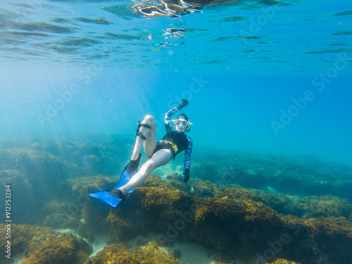 Wallpaper Mural A woman is swimming in the ocean wearing a black and yellow wetsuit Torontodigital.ca