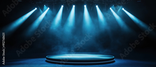 A dramatic stage illuminated by blue spotlight beams, creating an atmosphere of anticipation and creativity.