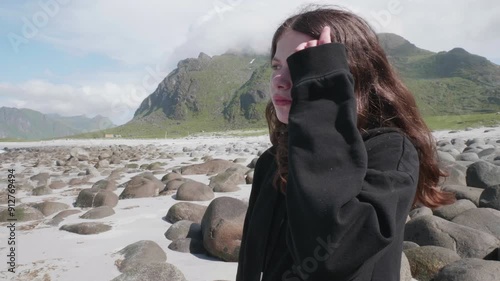 Portrait of a young girl at a beautiful beach on a sunny day in summer in Lofoten Norway photo