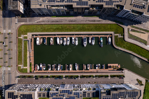 Noorderhaven recreational port with contemporary modern exterior facades of apartment buildings on either side and a few boats at anchor. Aerial top down view inland shipping river IJssel dock photo