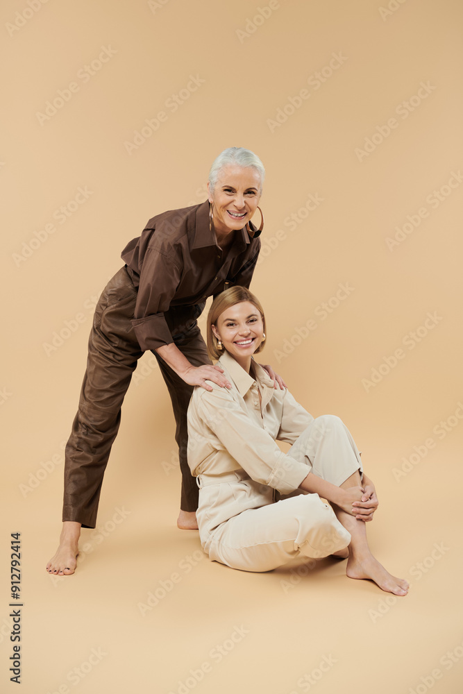 A mature woman joyfully connects with her adult daughter in a cozy setting. A mature woman joyfully connects with her adult daughter in a cozy setting.