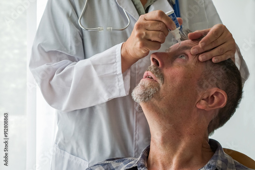 A doctor puts eyedrop medication into a man's eye during an appointment at the hospital.