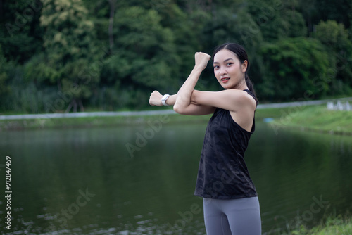 Young beautiful Asian woman doing stretching exercise in outdoor park.