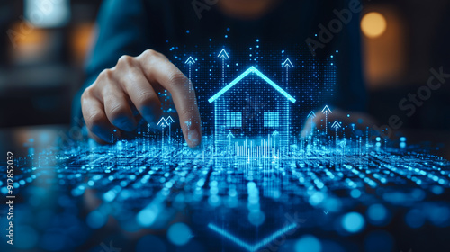 A hand interacts with a digital interface displaying holographic houses, symbolizing advanced real estate technology and futuristic home management solutions.