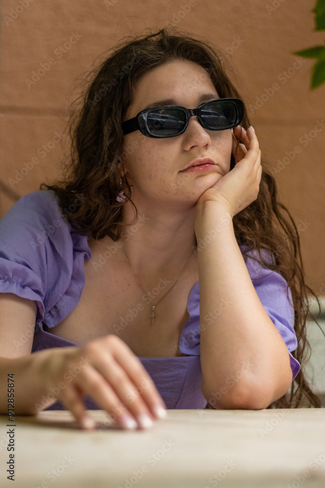 Woman sitting in violet dress and sunglasses. Summer concept. High quality photo. Woman sitting in violet dress and sunglasses. Summer concept. High quality photo.