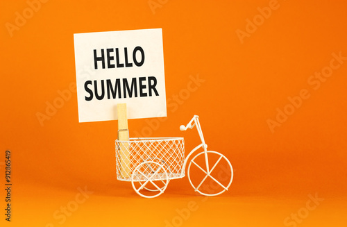 Hello summer symbol. Concept words Hello summer on beautiful white paper on wooden clothespin. Beautiful orange background. Bike model. Business lifestyle Hello summer concept. Copy space. photo