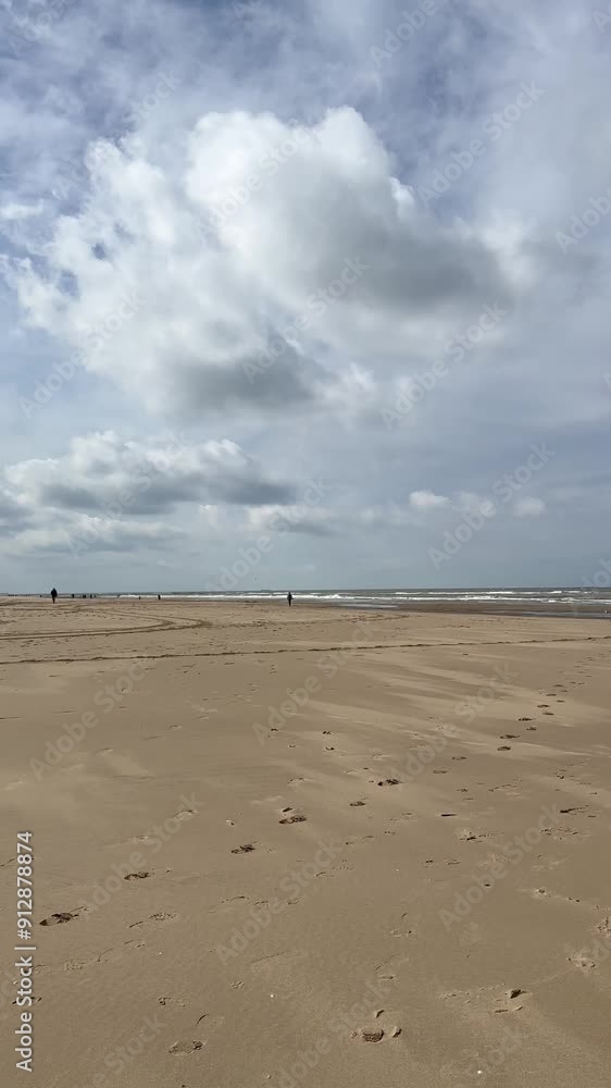 Beautiful view in summer over the beach in Katwijk aan Zee. People are resting near the sea. Houses for tourists. Beach umbrellas, rides, people swimming in the sea. Beach in Netherland. North Sea. Beautiful view in summer over the beach in Katwijk aan Zee. People are resting near the sea. Houses for tourists. Beach umbrellas, rides, people swimming in the sea. Beach in Netherland. North Sea.