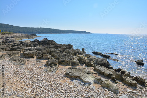 A rugged and rocky shoreline with a vast body of water visible in the background