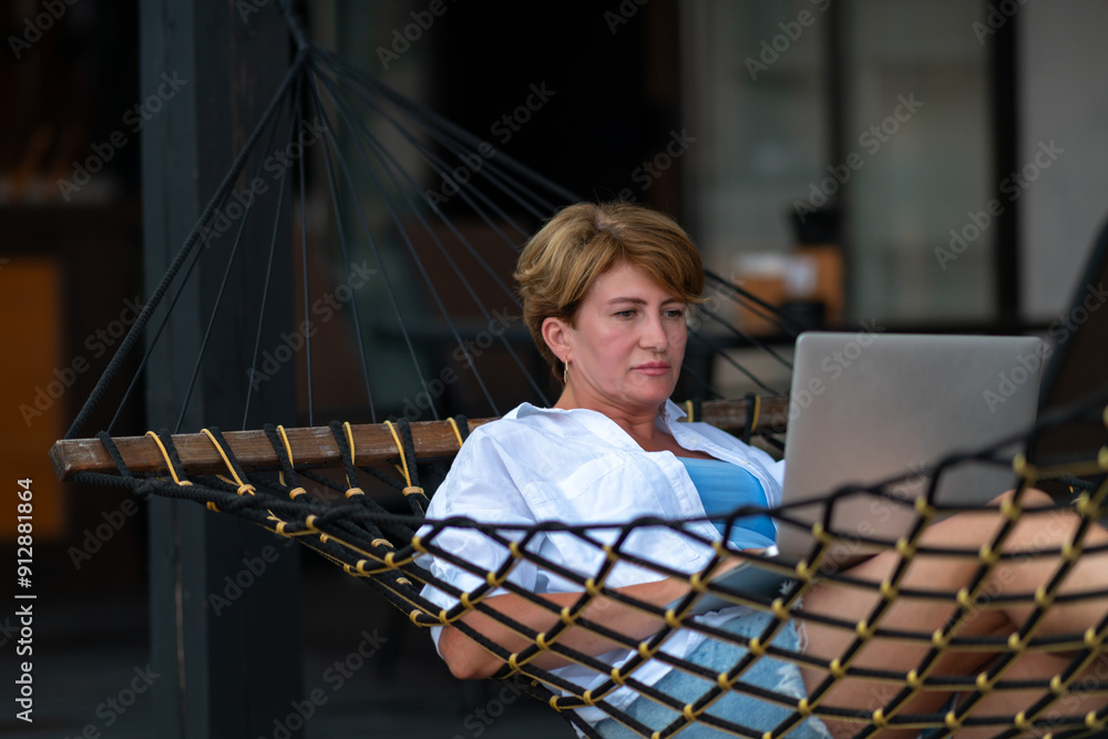 Woman with laptop in hammock.