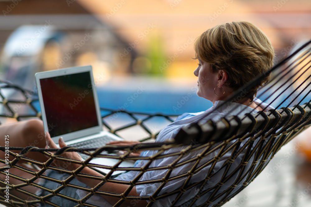 A woman looks at a laptop screen.