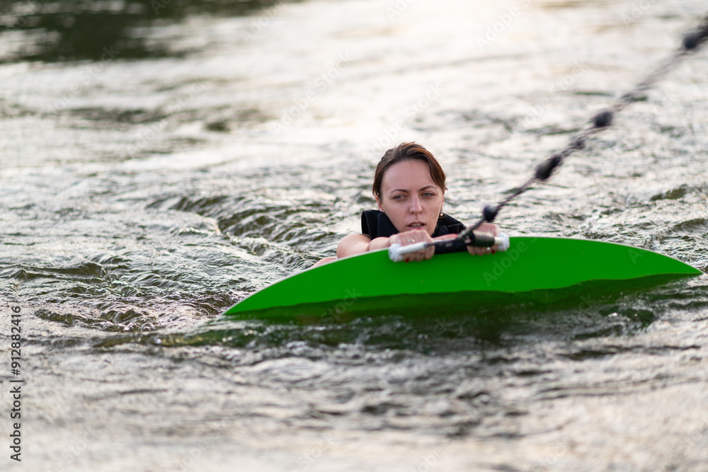 Obraz premium A girl is using her wakeboard in the water.