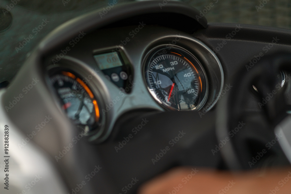 Speedometer and other sensors on the dashboard of a motorboat.