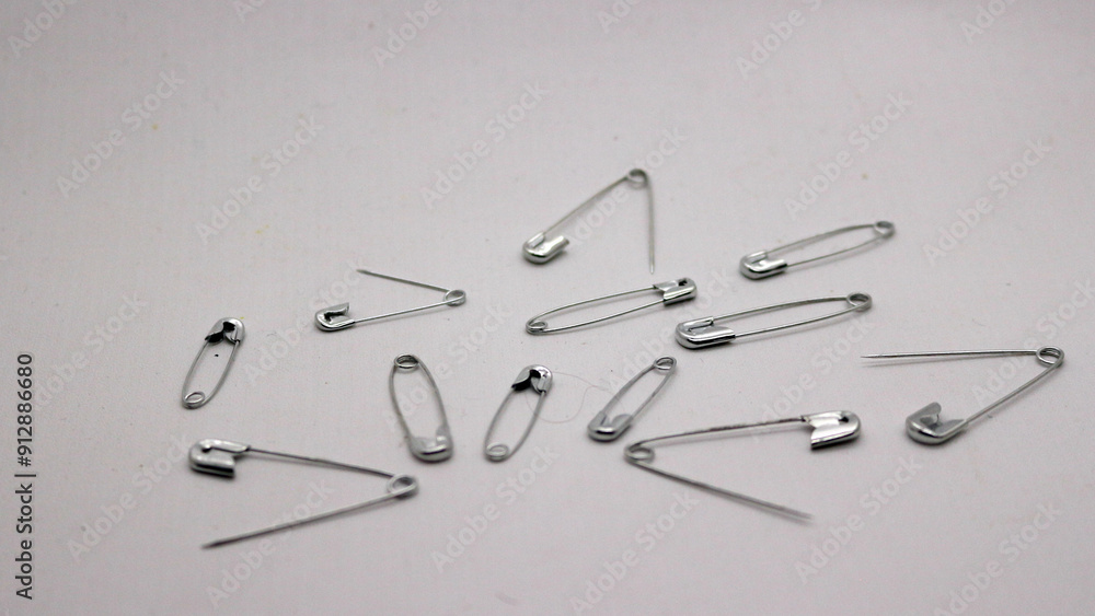 The safety pin is made of metal and silver in color. The safety pin is made of metal and silver in color.