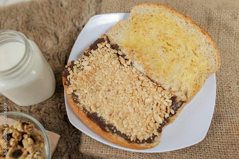 Bread with peanut, chocolate and butter spread on a table for breakfast
Bread with peanut, chocolate and butter spread on a table for breakfast