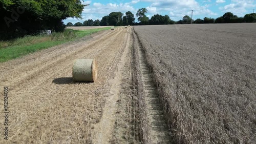 Drone shot of hay rolls in barley fields during harvest, in the second week of August, near the village of Chart Sutton, Kent, UK Rising to look north over the Weald of Kent photo