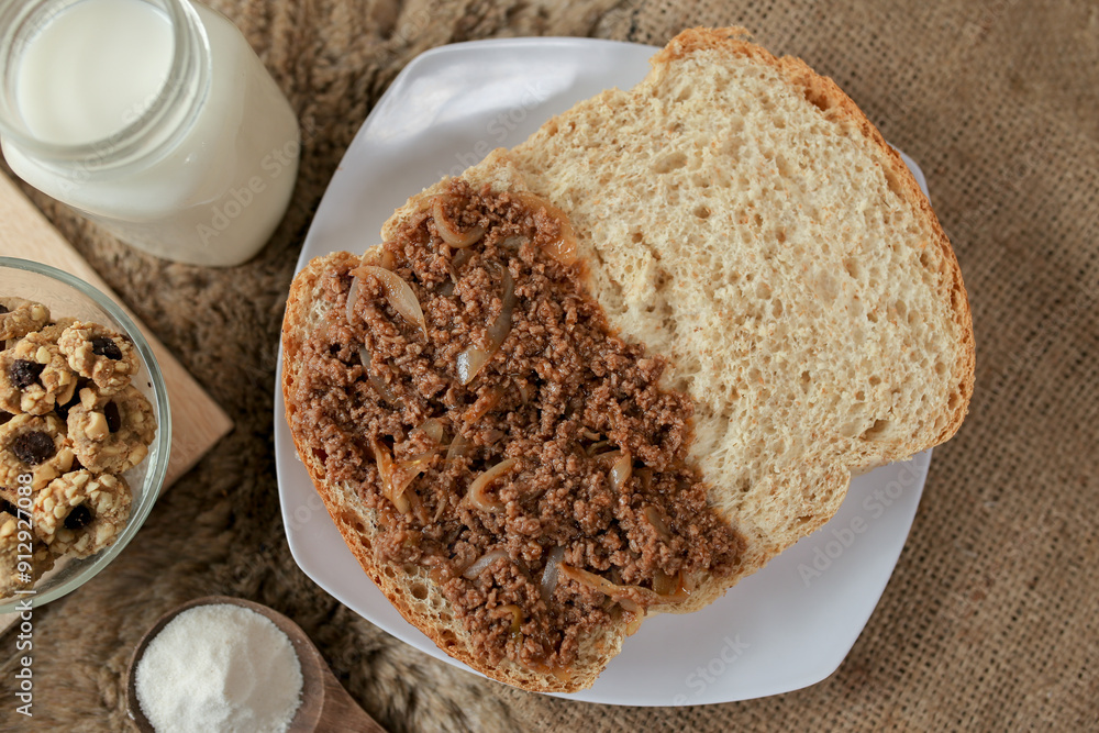 Bread with minced beef and union on a table. With white milk and snack for breakfast
Bread with minced beef and union on a table. With white milk and snack for breakfast
