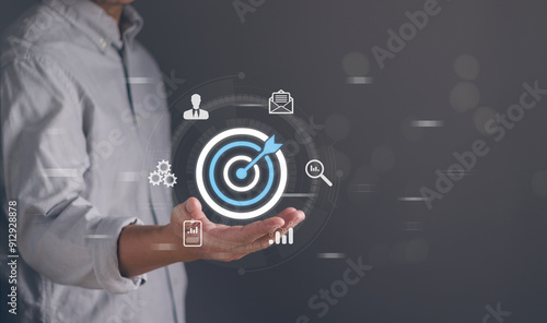 Goal and target concept ,Businessman show dart board and arrows on hand for setting business goals. Marketing solution Team goals for business ventures, planning for success photo