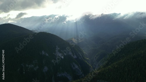 Aerial drone shot of Valea Prapastiilor as seen from the sky of Magura on a green sunny summer day. The romanian Carpathian mountains Piatra Craiului area seen from above. Top down footage of canyon.
 photo