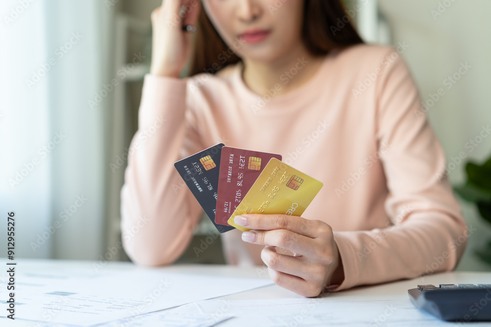 Debt and finance loan concept, Stressed woman holding a mock-up credit card and has an anxious facial expression. Debt and finance loan concept, Stressed woman holding a mock-up credit card and has an anxious facial expression.