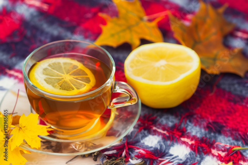 Plaid lemons and leaves with cup tea. cup book coffee concept. mug of tea with a slice of lemon and a plaid in autumn foliage. a mug of tea with a slice of lemon and colored foliage leaves in autumn.