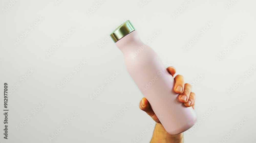 Closeup hand holding pink metal water bottle mock up isolated on white background, water container, template, copy space area