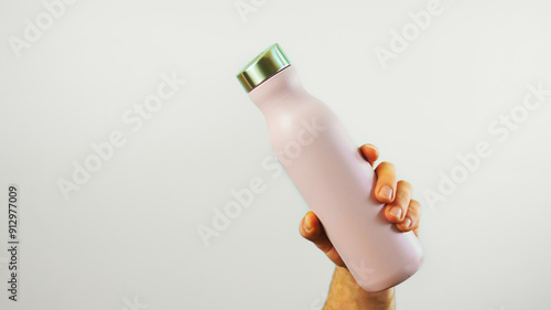Obraz na płótnie Closeup hand holding pink metal water bottle mock up isolated on white background, water container, template, copy space area w salonie