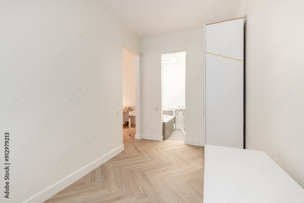 Minimalism Children, Young Adult Living Room Interior. Desk, Table Wardrobe Closet in Background. Open Door to Bathroom. White Walls and Ceiling. LED Light Minimalism Children, Young Adult Living Room Interior. Desk, Table Wardrobe Closet in Background. Open Door to Bathroom. White Walls and Ceiling. LED Light