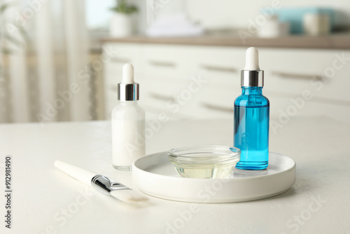 Peeling procedure. Bottles of chemical peel, bowl with liquid and brush on white table indoors