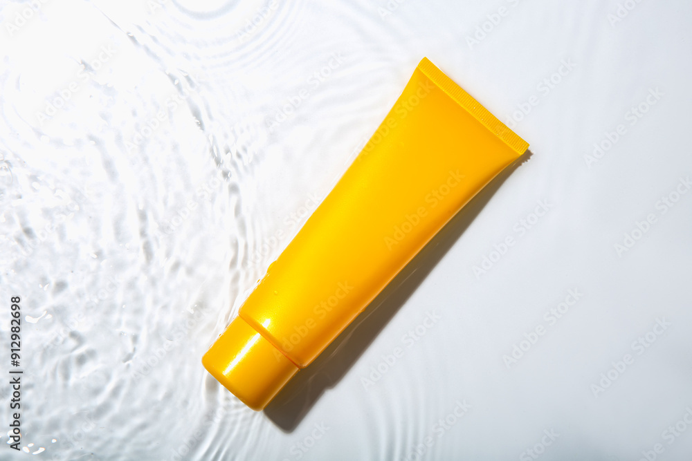 Cosmetic product. Tube with cream in water on light background, top view Cosmetic product. Tube with cream in water on light background, top view