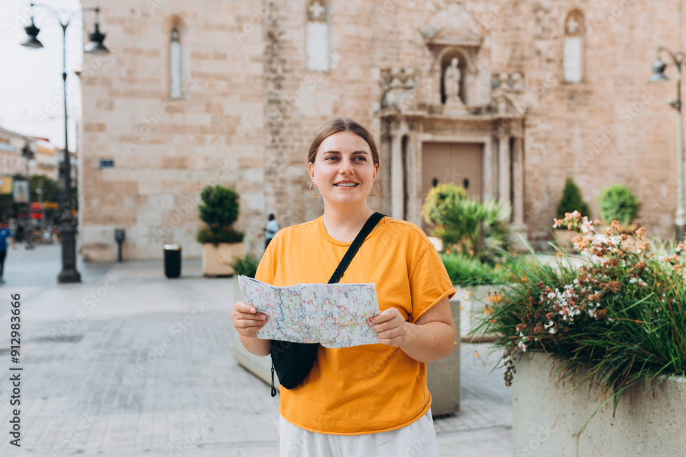 Obraz premium Young beautiful 30s woman looking city map at street, old town. Attractive young female tourist is exploring new city. Traveling Europe, High quality photo
