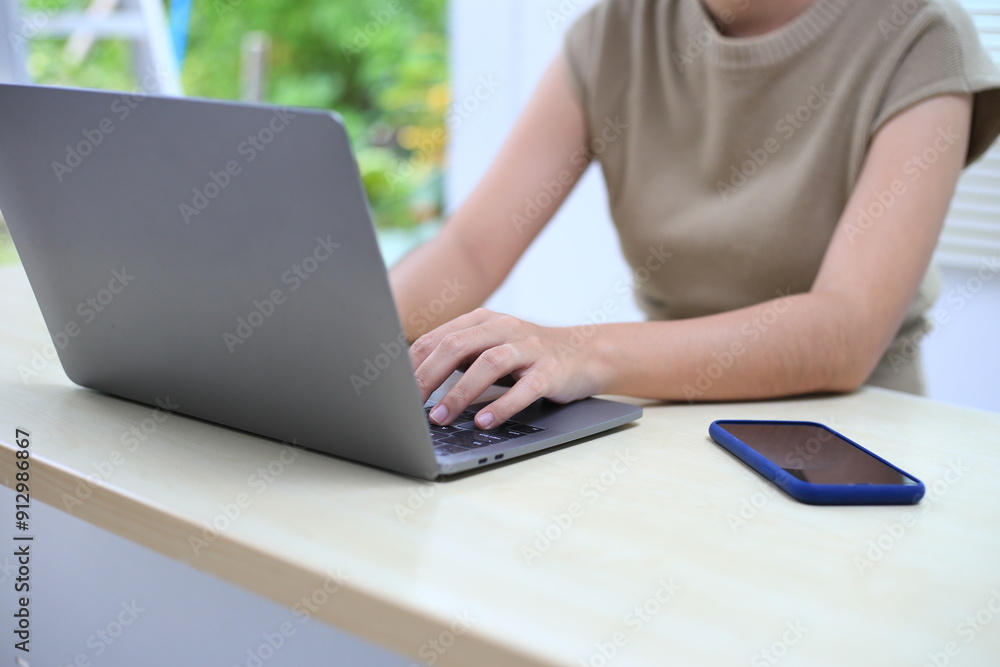 Fototapeta premium Successful Asian businesswoman sitting at desk working using laptop computer in office. Business and people concept. Businesswoman using laptop computer and working with documents.