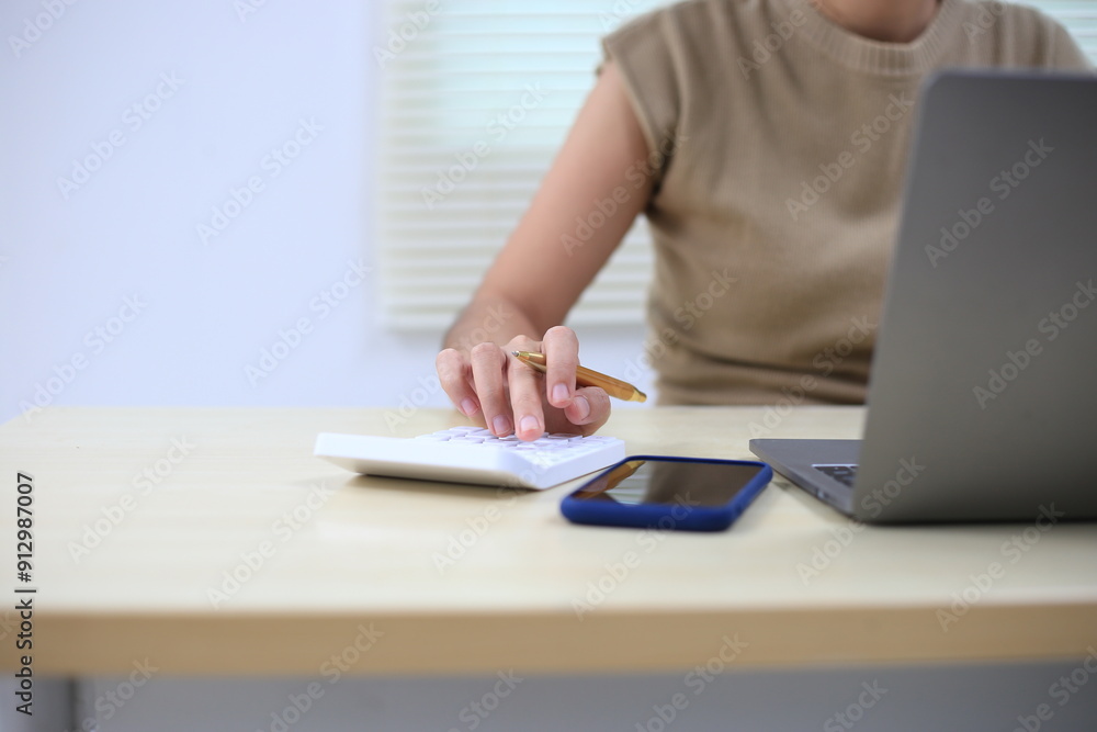 Fototapeta premium Successful Asian businesswoman sitting at desk working using laptop computer in office. Business and people concept. Businesswoman using laptop computer and working with documents.