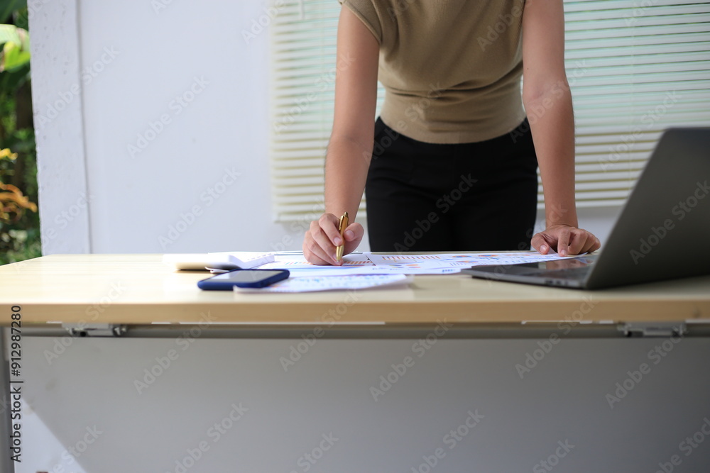 Fototapeta premium Successful Asian businesswoman sitting at desk working using laptop computer in office. Business and people concept. Businesswoman using laptop computer and working with documents.