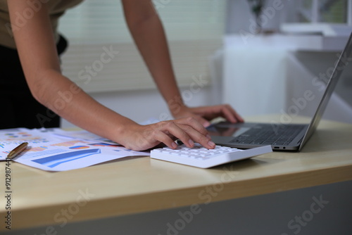 Successful Asian businesswoman sitting at desk working using laptop computer in office. Business and people concept. Businesswoman using laptop computer and working with documents.