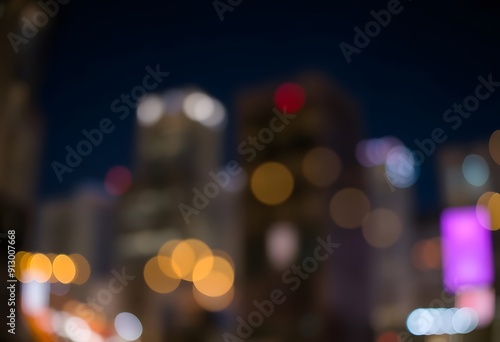 Blurred city skyline at night with colorful lights and bokeh effect