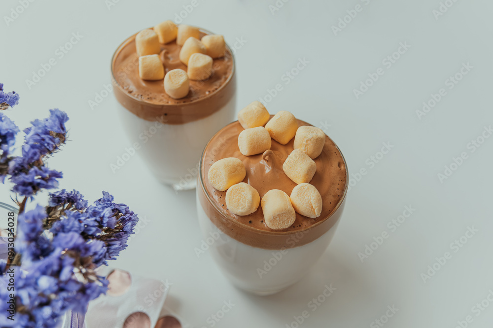 Dalgona coffee with marshmallows, whipped coffee with fluffy topping, and elegant presentation on white table Dalgona coffee with marshmallows, whipped coffee with fluffy topping, and elegant presentation on white table