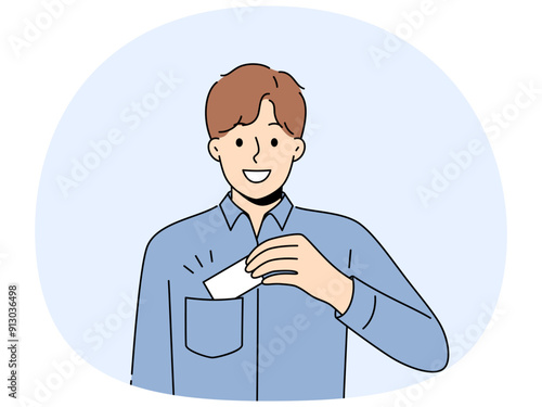 Man takes out business card from pocket to exchange contacts with potential partner or buyer and looks into camera with smile. Business guy in blue shirt wants to share contacts with new acquaintances