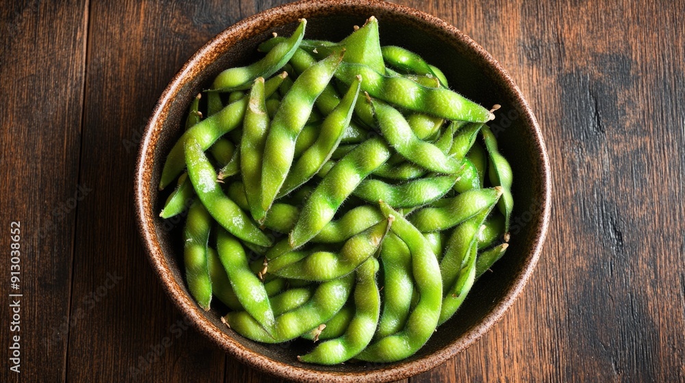 Freshly arranged edamame soybeans in a rustic bowl on a wooden surface Freshly arranged edamame soybeans in a rustic bowl on a wooden surface