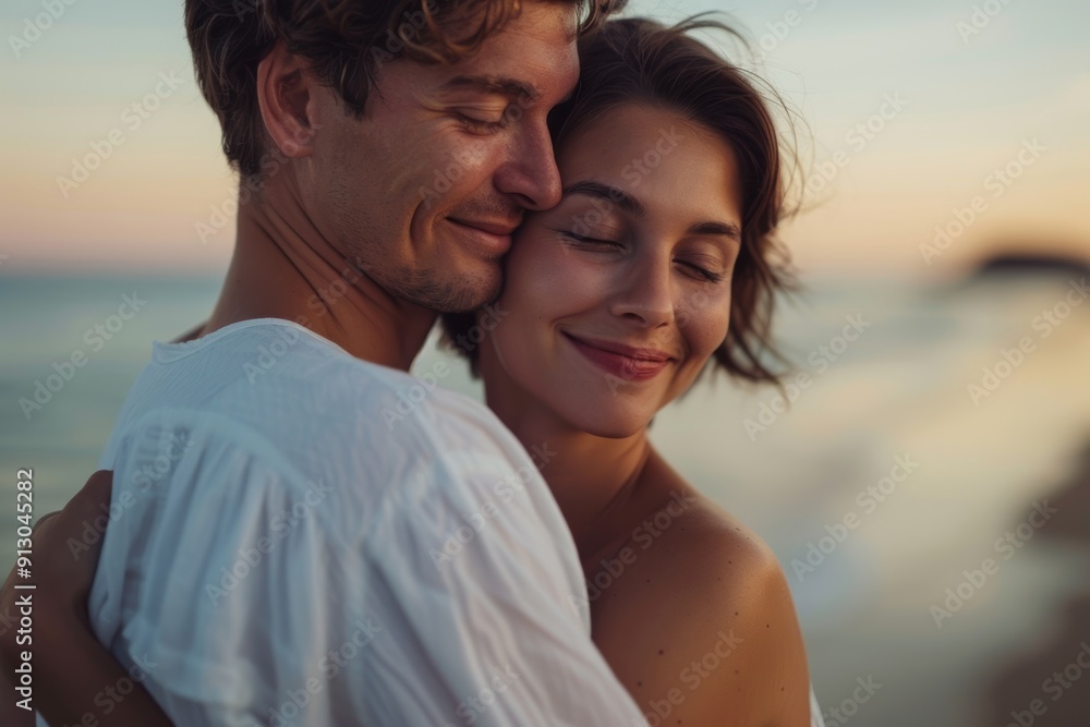 Honeymooners cuddling on the beach with love and tenderness. A Maldives beach vacationer kisses and embraces his wife from behind. Honeymooners cuddling on the beach with love and tenderness. A Maldives beach vacationer kisses and embraces his wife from behind.