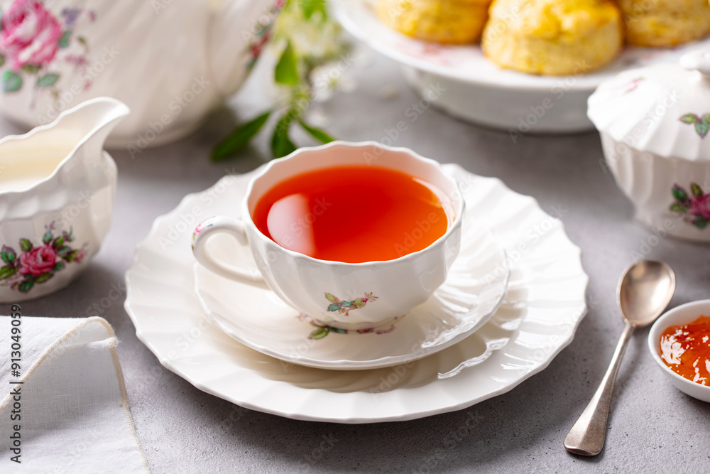 Cup of tea with scones with jam and milk. Grey background. Close up. Cup of tea with scones with jam and milk. Grey background. Close up.
